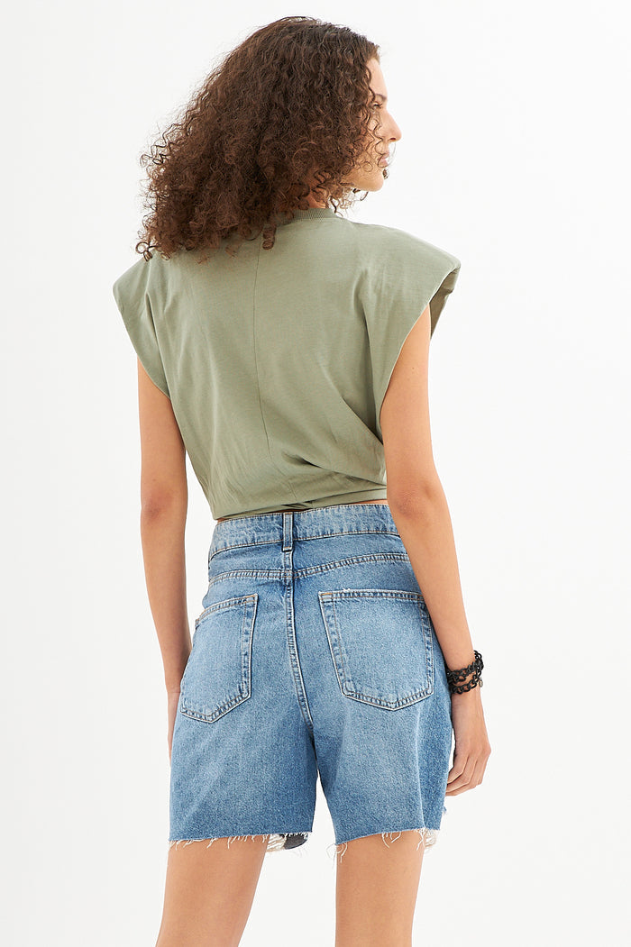 Back view of Gravity Grey padded muscle tee with structured shoulders and raw-hem denim shorts for a streetwear aesthetic.