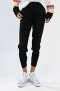 Model wearing Paris Black Knit Jogger Pants with drawstring waist and ribbed cuffs, styled with white high-top sneakers.