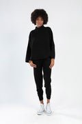 Model wearing a Paris Top Set in black, featuring a long-sleeve knit turtleneck and matching joggers with white sneakers.