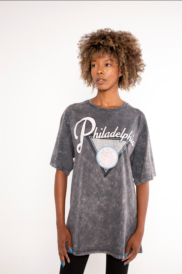 Model wearing a Philadelphia oversized acid wash graphic tee in charcoal grey with a vintage streetwear aesthetic.