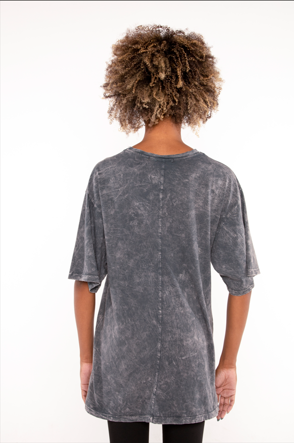 Back view of a person wearing an oversized Philadelphia acid wash graphic tee in carbon grey with streetwear fit.