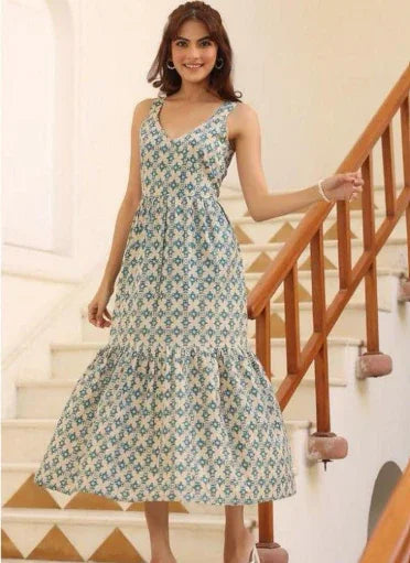 Woman wearing a sleeveless floral print maxi dress standing on indoor stairs