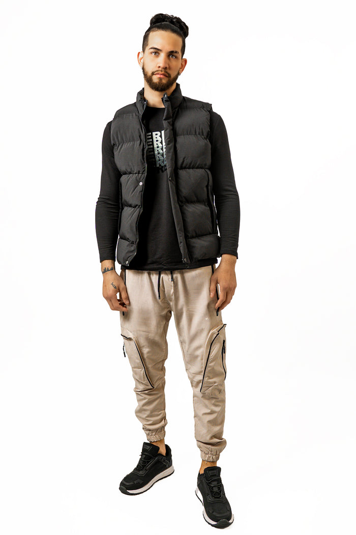 Model wearing the Randy black quilted puffer vest over a long-sleeve tee and beige cargo joggers for a streetwear look.