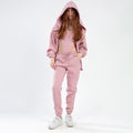 Model wears the Remi Bodysuit Set in salmon, featuring a cut-out bodysuit, matching drawstring joggers, and oversized hoodie.