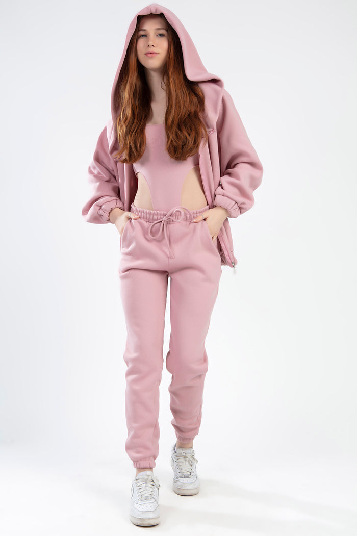 Model wearing the Remi Jacket Set in salmon pink featuring an oversized zip-up hoodie and matching joggers.