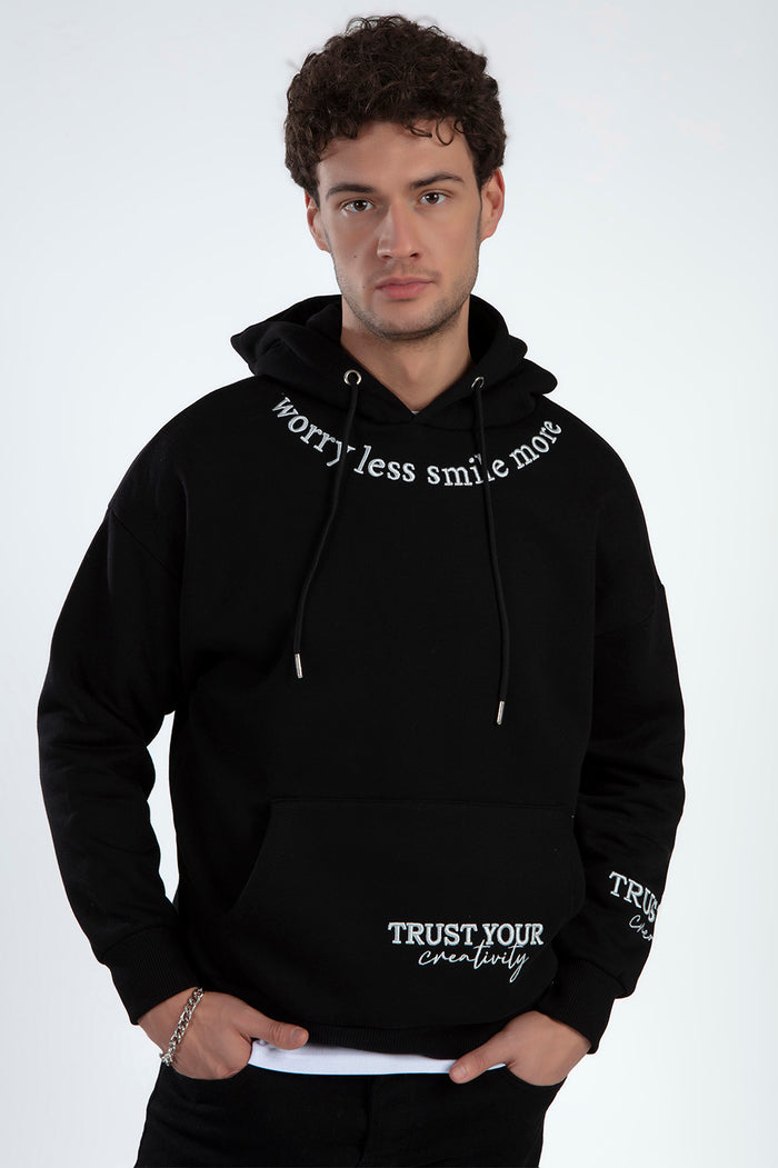 Men's black streetwear hoodie with Worry Less Smile More text around neck and Trust Your Creativity graphic on pocket.