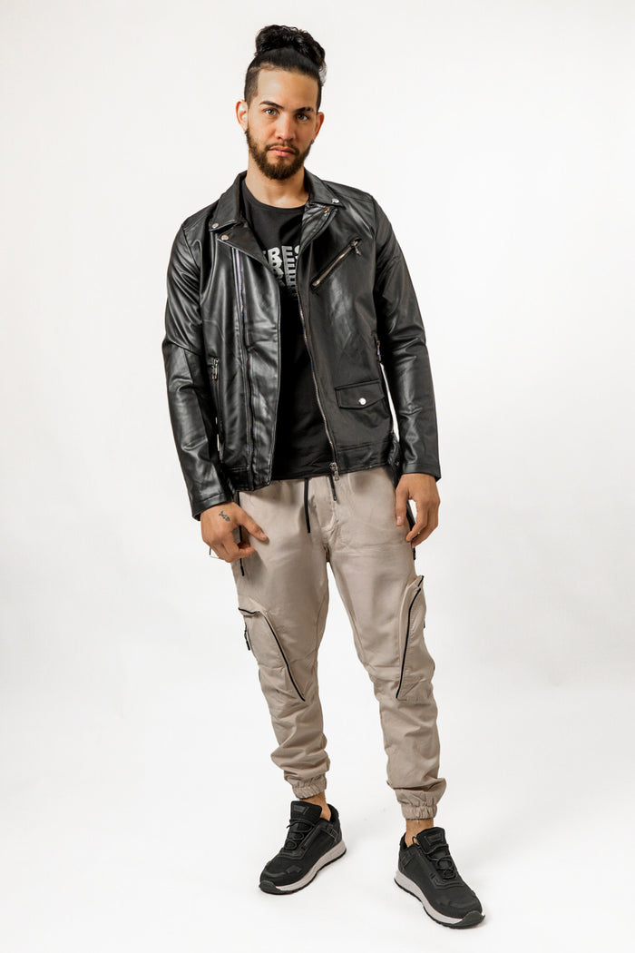 Model wearing a Russell black faux-leather biker jacket with silver hardware, styled with khaki cargo joggers.