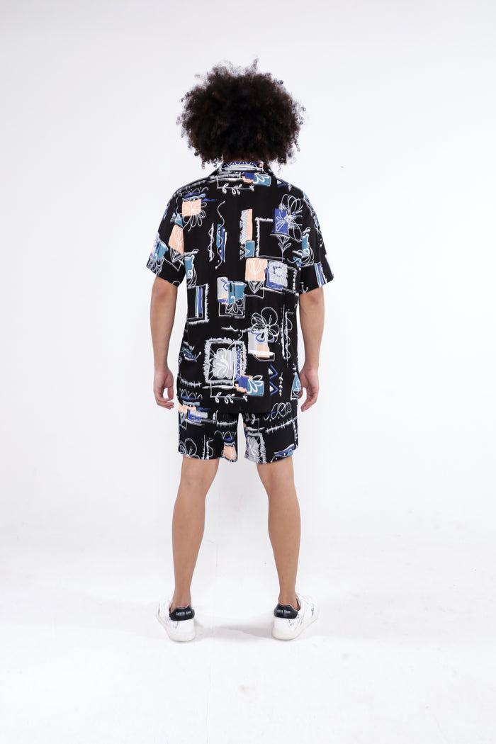 Back view of Ryland Two-Piece Top Set, featuring a black button-up shirt and shorts with abstract streetwear patterns.