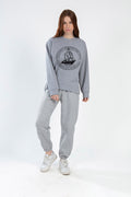 Model wearing a light grey oversized Sailing Top with a black vintage ship graphic and matching joggers.