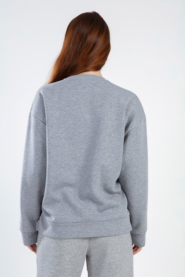 Back view of a woman wearing an oversized light grey Sailing Top sweatshirt with a modern streetwear fit.