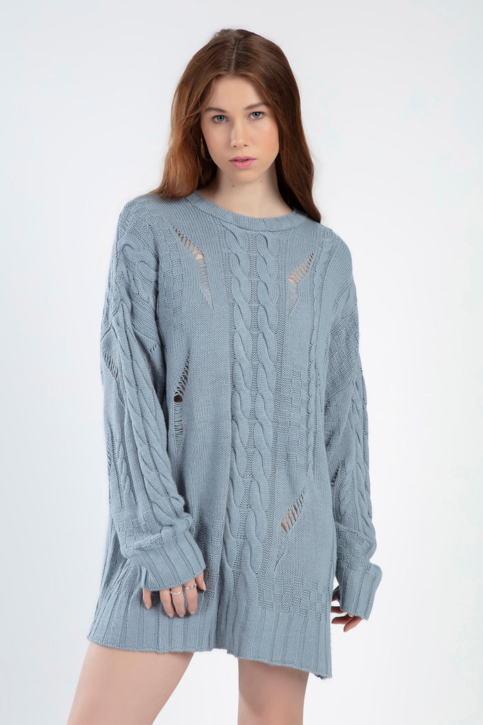 Model wearing the Saylor blue oversized cable knit sweater featuring distressed holes and a loose pullover fit.