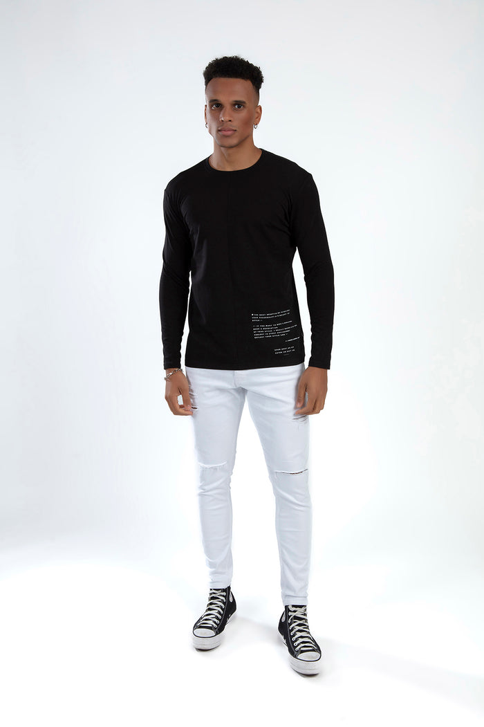 Man in a Show Must Go On black long-sleeve graphic tee by Carbon Jeans, paired with white distressed streetwear denim.