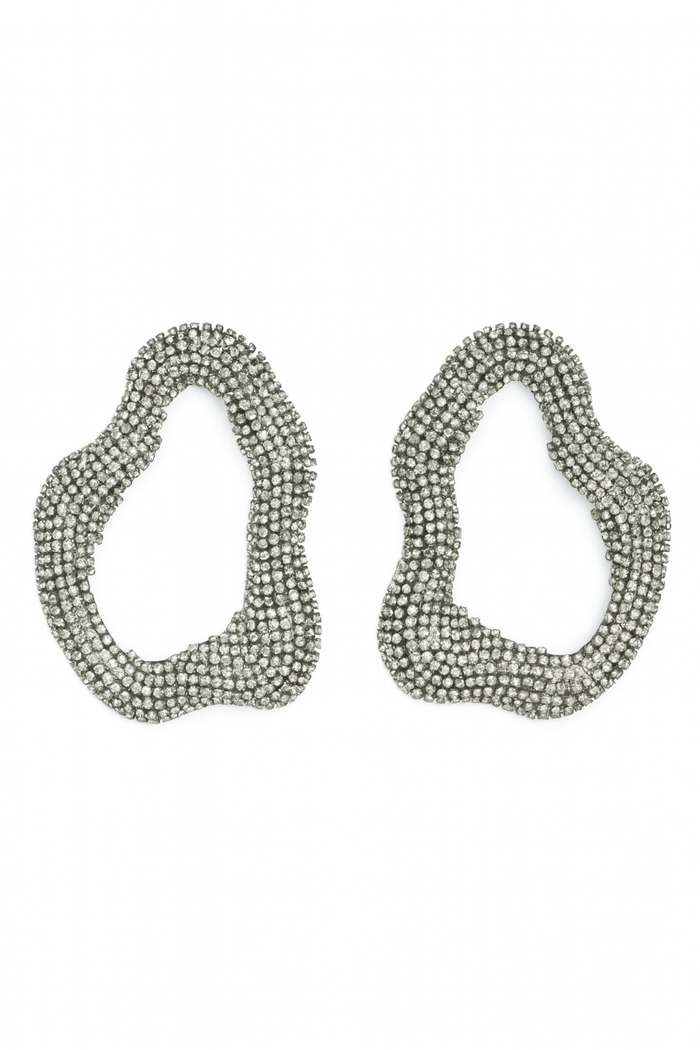 Silver-tone abstract statement earrings with an open sculptural shape covered in sparkling rhinestones.