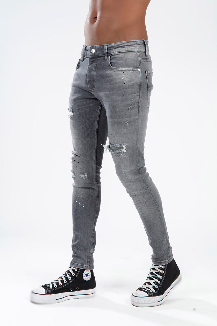 Men's Simon slim fit grey washed denim jeans with distressed details and paint splatter on white background.