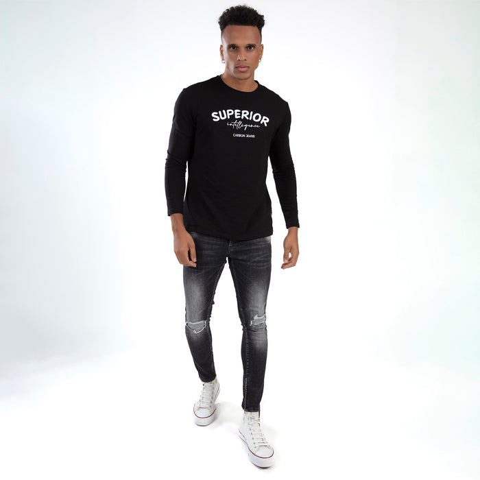 Model in black Carbon Jeans Superior Intelligence long-sleeve shirt, distressed skinny jeans, and white sneakers.