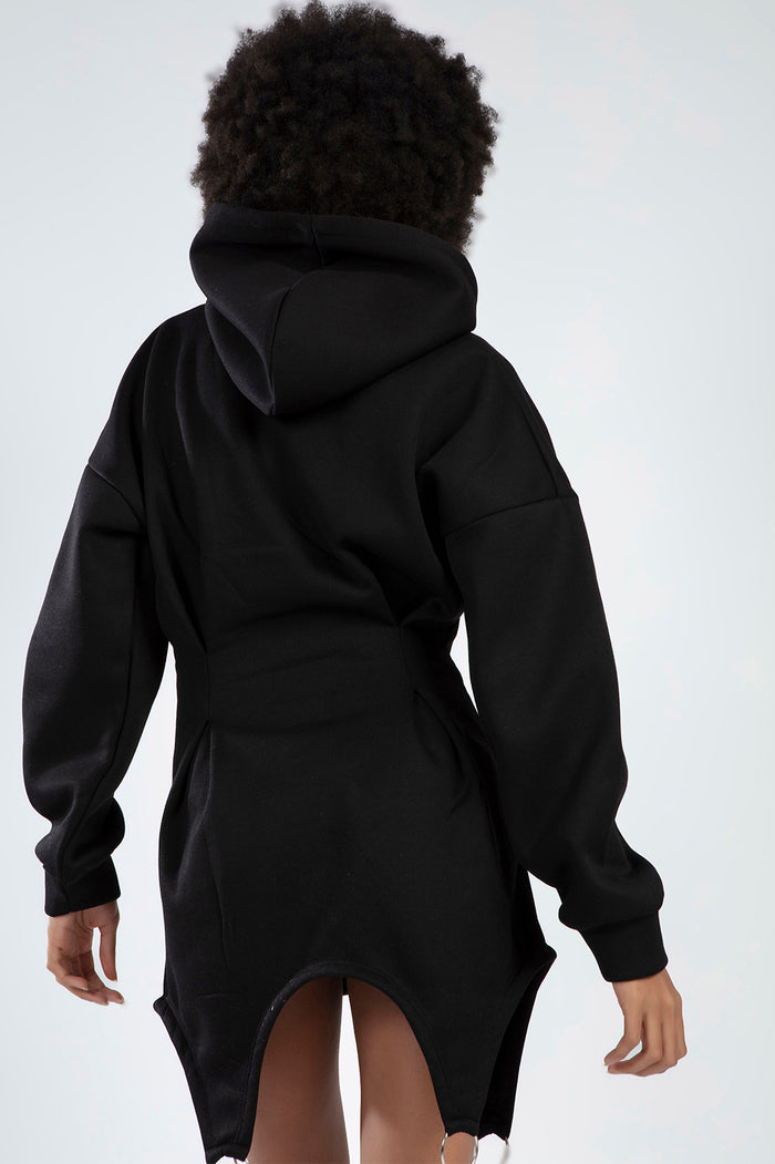 A person wearing a black hooded garment with a unique cut and long sleeves, showcasing a stylish back view.