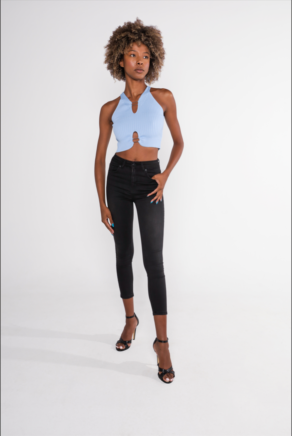 Model wears the Tori light blue ribbed halter top with front cutouts and metal ring details, paired with black jeans.