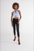Model wears the Tori light blue ribbed halter top with front cutouts and metal ring details, paired with black jeans.